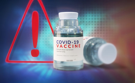 warning sign and Coronavirus vaccine dose, transparent glass bottle with the vaccine against...