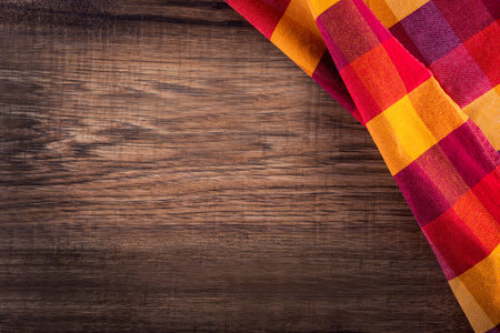 Top view of checkered napkin on empty wooden table