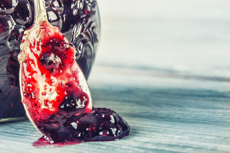 Close up of thick sweet strawberry jam with old spoon. Top view of fruity jam.の写真素材