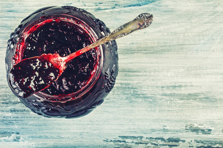Close up of thick sweet strawberry jam with old spoon. Top view of fruity jam.の写真素材