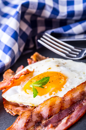 Ham and Egg. Bacon and Egg. Salted egg and sprinkled with black pepper and green herb decoration. English breakfast.の写真素材