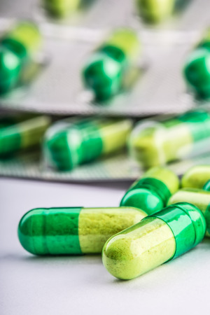 Pills. Tablets. Capsule. Heap of pills. Medical background. Close-up of pile of yellow green tablets - capsuleの写真素材