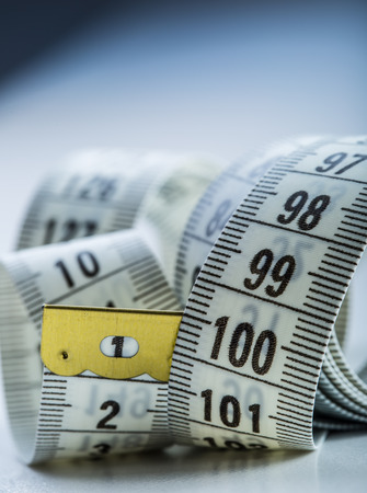 Curved measuring tape. Measuring tape of the tailor. Closeup view of white measuring tape