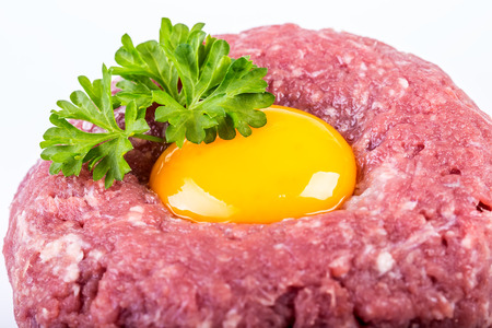 Raw beef .Tasty Steak tartare. Classic steak tartare over white. Ingredients: Raw beef meat salt...