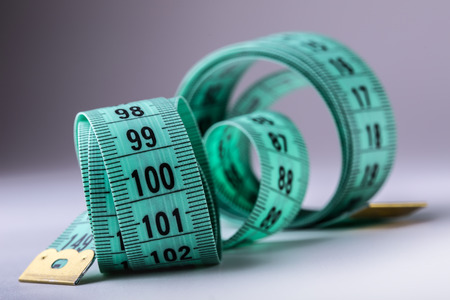 Curved measuring tape. Measuring tape of the tailor. Closeup view of Green measuring tape.