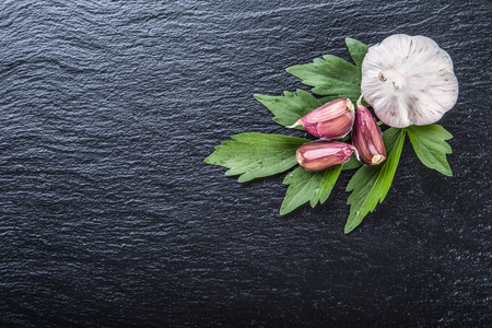 Garlic. Fresh Garlic. Cloves of garlic with parsley herb top leaves and pepper four colours.の写真素材