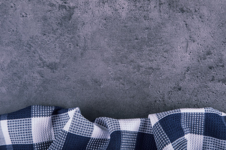 Top view of checkered kitchen tablecloth on granite -  concrete - stone background. Free space for your text or products.の写真素材