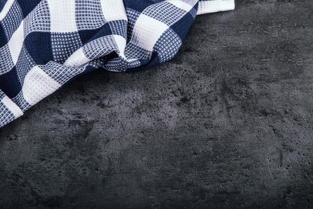 Top view of checkered kitchen tablecloth on granite -  concrete - stone background. Free space for your text or products.の写真素材