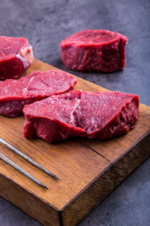 Steak. Raw beef steak. Fresh raw Sirloin beef steak sliced o Herb - Rosemary decoration.の写真素材