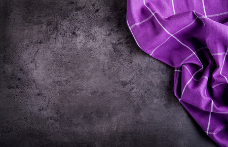 Top view of checkered kitchen purple tablecloth on concrete - stone - marble -  wooden background. Free space for your text or products.の写真素材