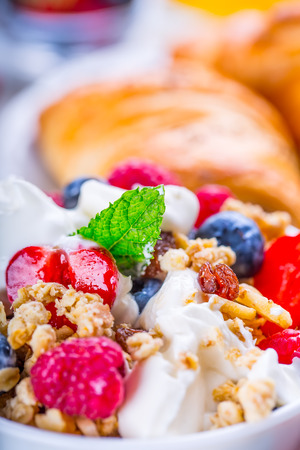Muesli with yogurt and berries on a wooden table. Healthy fruit and cereal brakfast.の写真素材