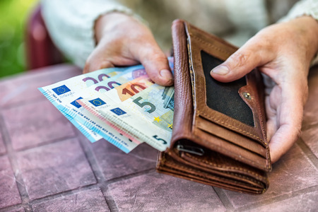 Pensioner woman holding in hands wallet with money.の写真素材