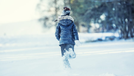 Young girl are playing with snow.Beauty Winter happy Girl Blowing Snow in frosty winter park or outdoors. Girl and winter cold weather.の写真素材