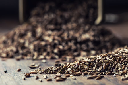 Cumin.Caraway seeds on wooden table. Cumin in vintage bronze bowl and spoon.