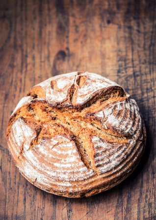 Bread.Fresh round crisp bread with caraway on wooden table.