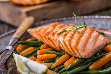 Salmon fillets. Grilled salmon, sesame seeds herb decoration on vintage pan or black slate board. fish roasted on an old wooden table.Studio shot.の写真素材