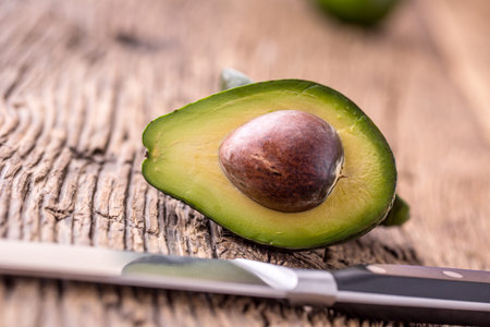 Avocado. Cut avocado on a oak wood background table. Selective focus.