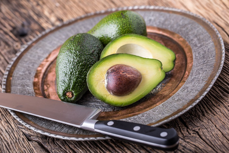 Avocado. Cut avocado on a oak wood background table. Selective focus.の写真素材
