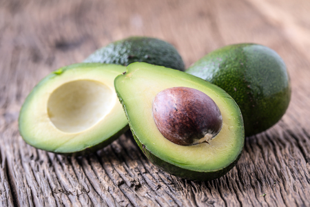 Avocado. Cut avocado on a oak wood background table. Selective focus.の写真素材
