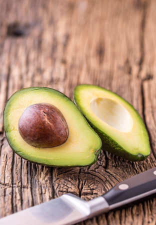 Avocado. Cut avocado on a oak wood background table. Selective focus.
