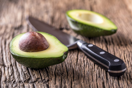 Avocado. Cut avocado on a oak wood background table. Selective focus.
