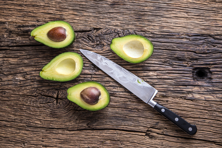 Avocado. Cut avocado on a oak wood background table. Selective focus.の写真素材