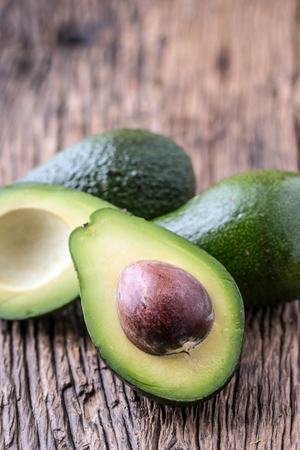 Avocado. Cut avocado on a oak wood background table. Selective focus.の写真素材