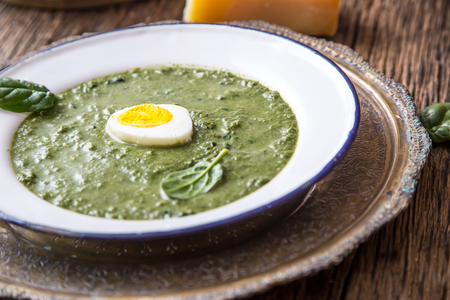Spinach soup. Portion spinach soup with egg and cheese parmesan in retro style.の写真素材