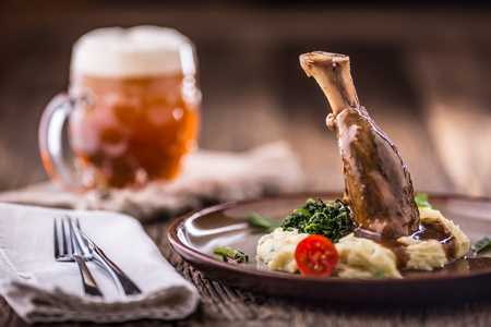 Lamb shank.Confit lamb shank with mashed potatoes spinach and draft beer in pub or restaurant.の写真素材