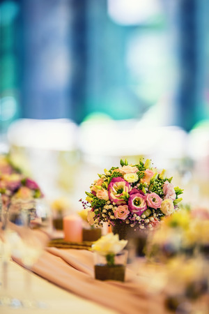 Wedding table setting. Beautiful table set with flowers and glass cups  for some festive event, party or wedding reception.の写真素材