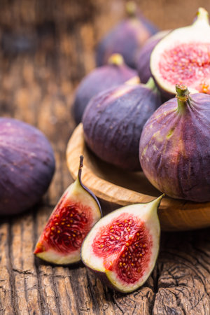 Figs. A few figs in a bowl on an old wooden background.
