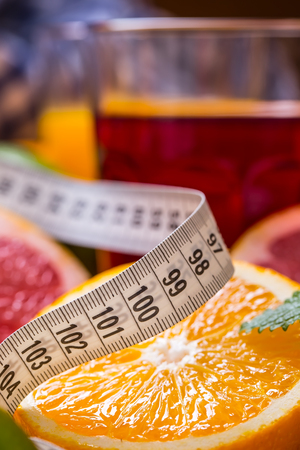 Measure tape and fresh citrus fruit orange lemon tangerine lime lemon and grapefruit.の写真素材