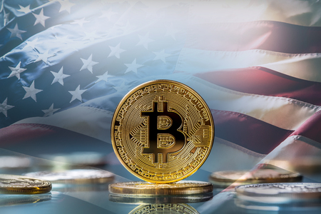 Bitcoin. Golden and silver bitcoins - virtual cryptocurrency. American flag in the background.の写真素材