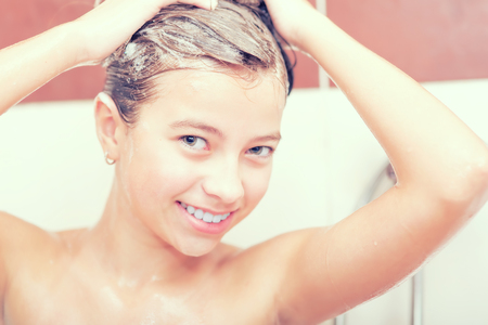 Teenage girl in bathroom is showering. Morning and evening hygiene.の写真素材