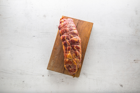 Pork neck. Smoked pork neck on wooden board.の写真素材