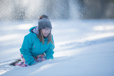 Happy young Pre-Teen girl in warm clothing  playing with snow. の写真素材