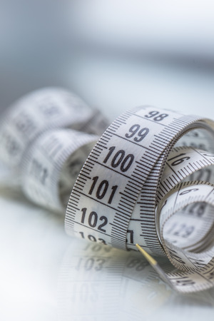 Curved measuring tape. Measuring tape of the tailor. Closeup view of white measuring tape.の写真素材