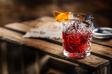 Cocktail Negroni on a old  wooden board. Drink with gin, campari martini rosso and orange.の写真素材