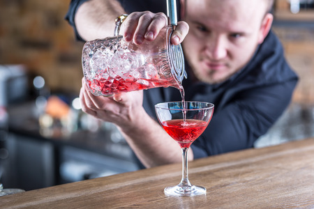 Barman in pub or restaurant  preparing a cocktail drink.の写真素材