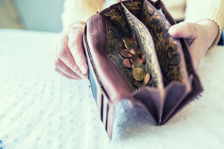 Pensioner woman holding in hands wallet with euro coins.の写真素材