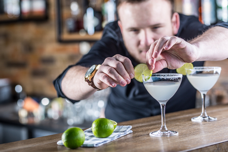 Barman in pub or restaurant  preparing a cocktail drink margarita.の写真素材