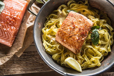 Pieces of roasted salmon with pasta tagliatelle lemon and basil.の写真素材