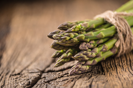 Bunch of fresh asparagus on rustic oak table.の写真素材