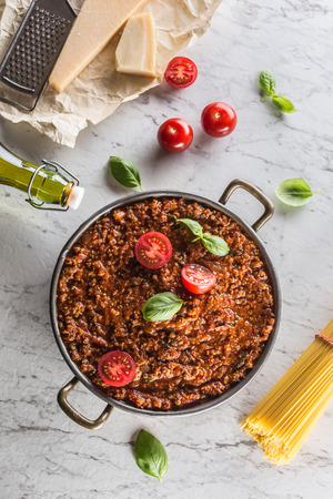 Classic italian bolognese sauce with ingredients pasta spaghetti olive oil tomatoes basil and parmesan cheese.の写真素材