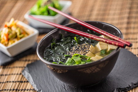 Traditional japanese soup Miso with tofu seaweed chopsticks and young onion.の写真素材