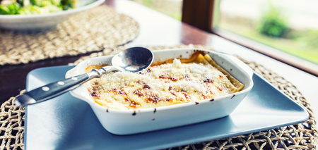 Portion of Lasagme bolognese in dish on table in restaurant.の写真素材