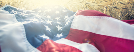American flag lies on the golden wheat field.