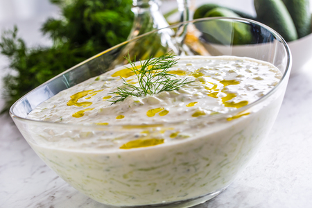Greek dip sauce or dressing tzatziki prepared  with grated cucumber sour cream yogurt olive oil and fresh dill.の写真素材