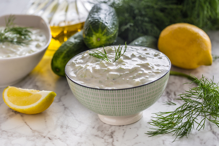 Greek dip sauce or dressing tzatziki prepared  with grated cucumber sour cream yogurt olive oil and fresh dill.の写真素材