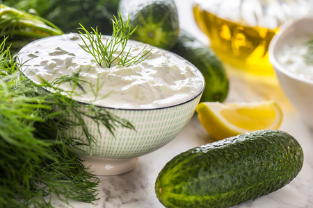 Greek dip sauce or dressing tzatziki prepared  with grated cucumber sour cream yogurt olive oil and fresh dill.の写真素材